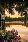 USA, New York. Adirondack Park, Saranac Lake, Hoel Pond, view of sunrise past boathouse. Art Print